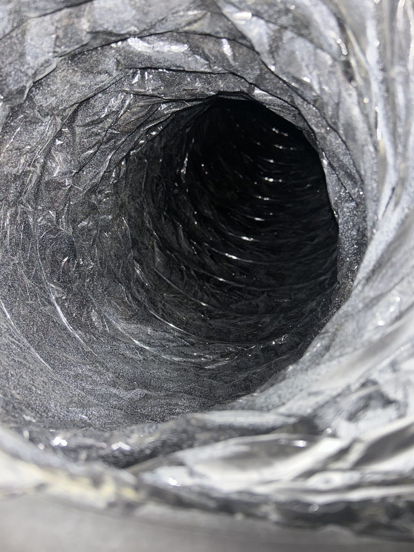 Clean flexible duct interior with the foil liner clearly visible