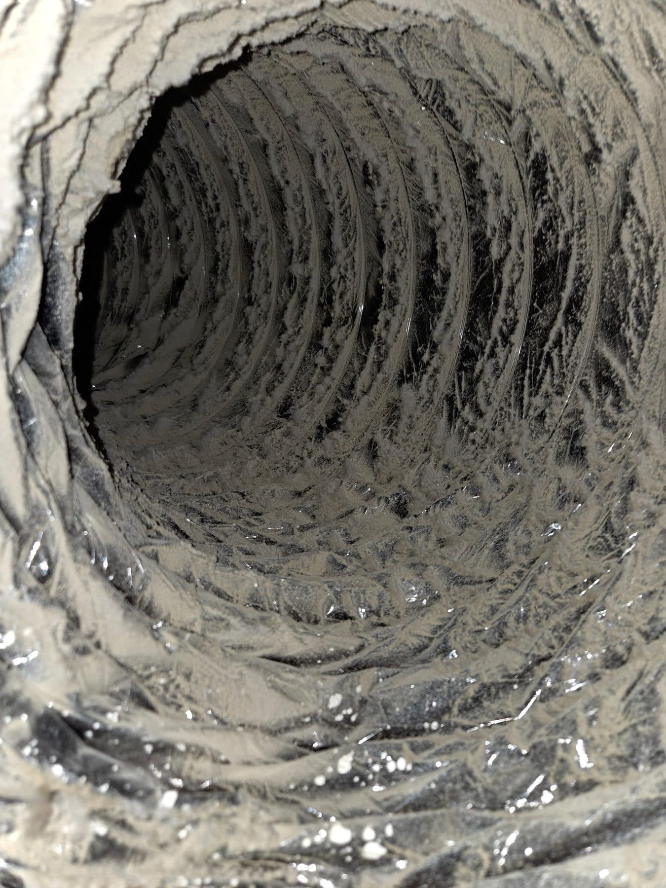 Close view of dust layered along the interior wall of a flexible air duct