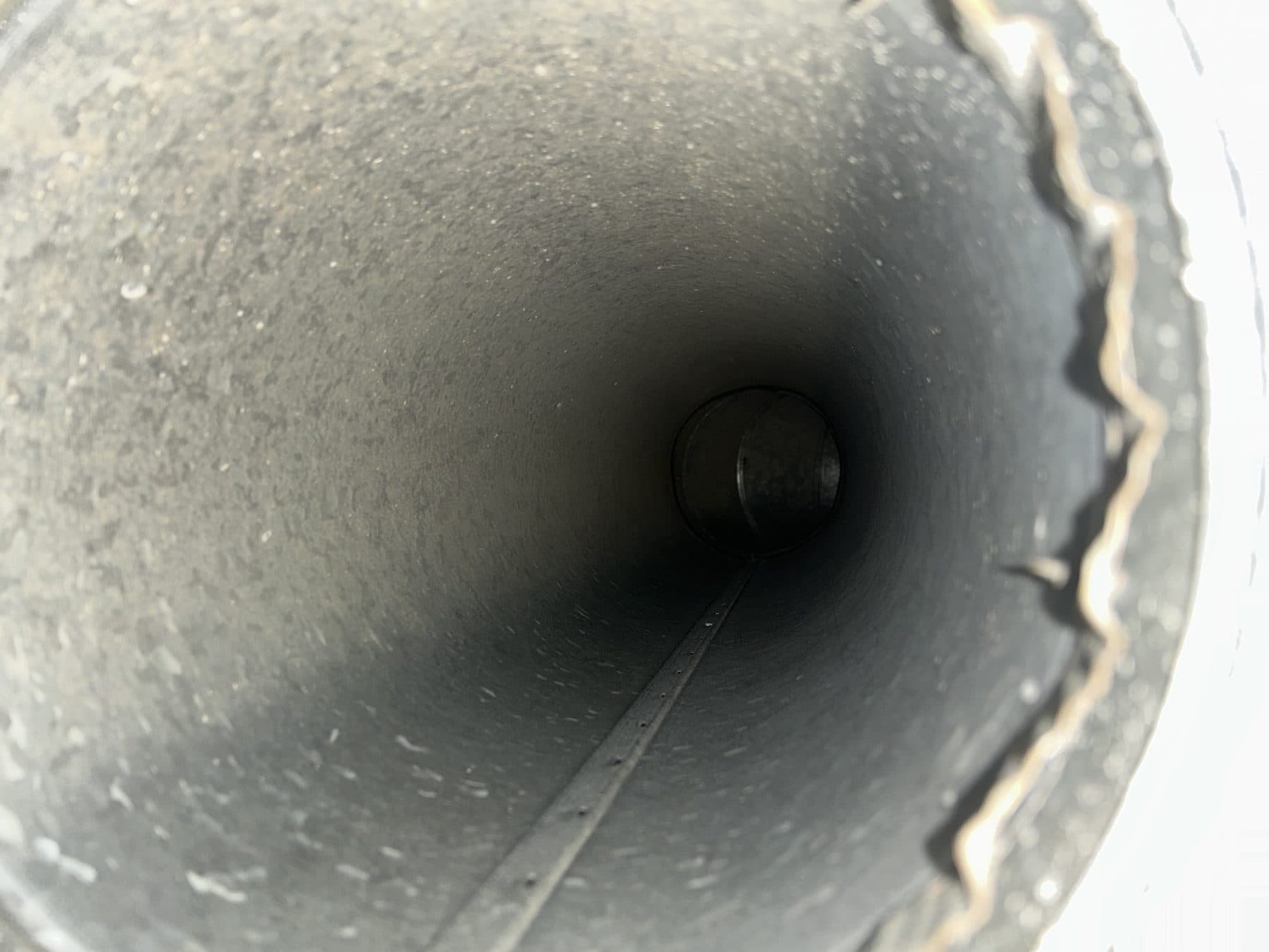 Interior of a rigid round duct trunk line showing clean bare metal
